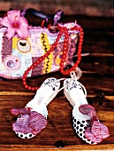 Sandals decorated with jungle flower and handbag on wood