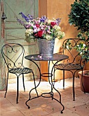 Garden terrace with chairs and table made of black painted iron