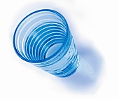 Close-up of blue glass of mineral water on white background