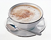 Cup of cappuccino with spoon on white background
