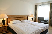 Bedroom with bed, cushion, lamp and sofa in hotel, Germany