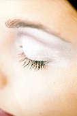 Close-up of woman's eyelid wearing silver eye shadow
