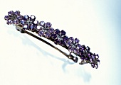 Close-up of purple flower barrette on white background