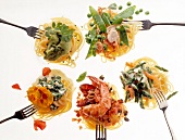 Five type of pasta dishes served with forks on white background