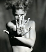 Woman stretching out her hand saying Do not touch me, written on palm, Black and White