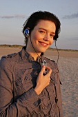 Janine Frau hört am Strand Musik