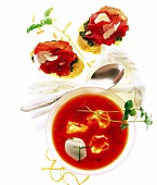 Basil Carpaccio on baguette, tomato-orange and chilli soup on white background
