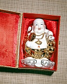 Close-up of laughing Buddha statue in red box
