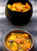 Pumpkin curry and potatoes in rustic bowls