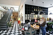 People in caf with staircase and black-white tiled floor, Germany