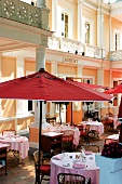 Laid tables and sunshades on terrace in Laurent restaurant, Paris, France