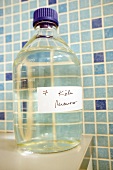 Close-up of sample liquid in bottle with markings against tiled wall