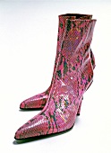 Pairs of pink boots made of snake leather on white background