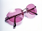 Close-up of rimless pink glasses on white background