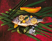 Fisch mit Reis und Papaya in Blättern, ganz, Zitronenscheiben