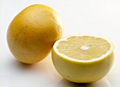 Close-up of whole and half grapefruit on white background
