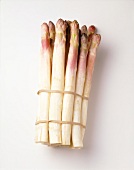 Bunch of asparagus with pink tips on white background
