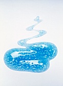 Close-up of light blue blob of exfoliating gel on white background