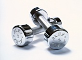 Close-up of two pound silver dumbbells on white background