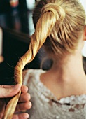 blonde Frau mit langen Haaren Zopf, eine Strähne um Zopfgummi