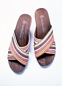 Pair of sandals with striped pattern strap on white background