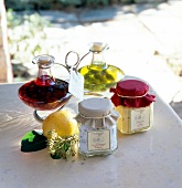 Glass jar with vinegar and oil bottles on marble