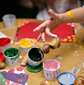 Kinderhand, Fingerfarbe, selbstge- machte Stempel aus Kartoffeln