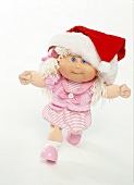 Cabbage patch kid doll with Santa hat on white background