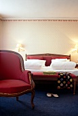 Bedroom with red bed and chair in Hotel Post