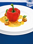 Red pepper with petoncles and sauce on white plate