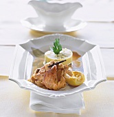 Roasted rabbit with lemon, garlic, white wine and vanilla in white serving plate