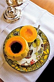 Fruchtkaltschale in Honigmelone serviert auf Tellern mit Obstdekor