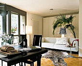 Living room with white sofa, black dining table, chair and designer lights
