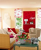 Wohnzimmer in Beige mit Farbakzenten in Rot, Sofa geflochten, Glastisch