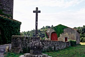 Sculpture of cross in the lawn of a stone house