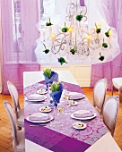 Laid out table with purple table cloth and chandelier in tulle, elevated view