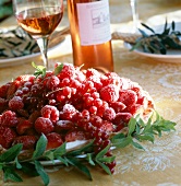 Variety of red berries with rose wine on table