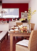 Esstisch in Küche in Rot-Weiß, Äpfel als Tischdeko, Stühle geflochten