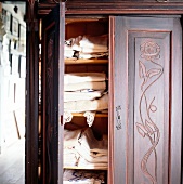White laundry in open antique cabinet with country style door