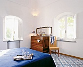 Hotelzimmer in blau-weiß, Doppelbett Kommode, Spiegel, Stuhl u. Fenster