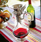 Rotwein in Dekantier-Karaffe aus Glas mit Griff und Deko aus Metall