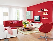 View of large living room with red and white furniture and flat screen TV on red wall