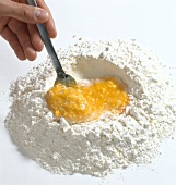 Hand mixing egg yolks and corn flour with spoon, step 2