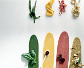 Green, yellow and red pasta dough with ingredients on white background
