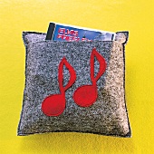 Kissen aus Filz in Grau, Applikation Noten in Rot, mit Tasche für CD