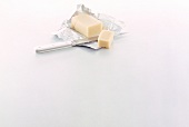 Piece of butter with knife on silver foil