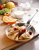 Crepe with raspberries and orange sauce in pan