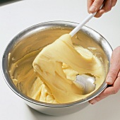 Hand mixing smooth dough in bowl