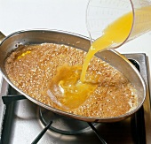 Lime and orange juice being poured in hot butter