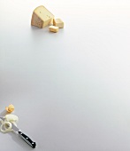 Cheese with onion rings and knife on white background, copy space